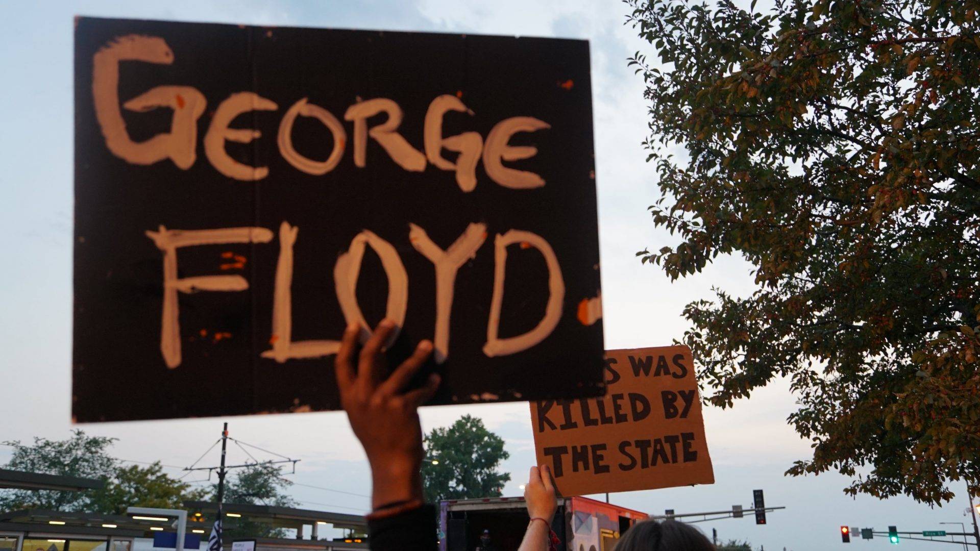 Protesters hold signs reading "George Floyd" and "Jesus was killed by the state" at a Sept. 23 Breonna Taylor rally in Minnesota