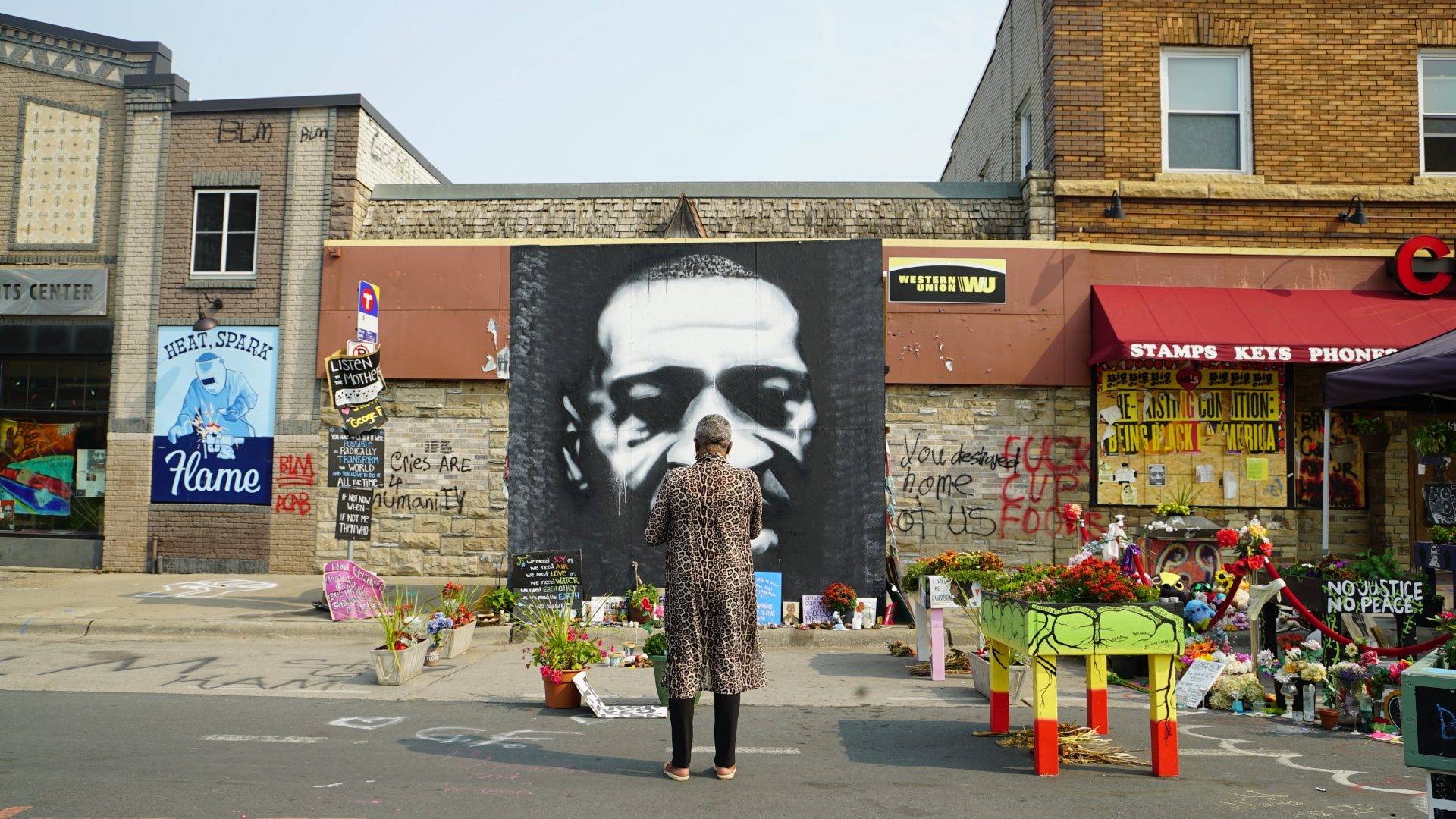 A woman stands outside a mural for George Floyd at 38th and Chicago on Sept. 20, 2020.