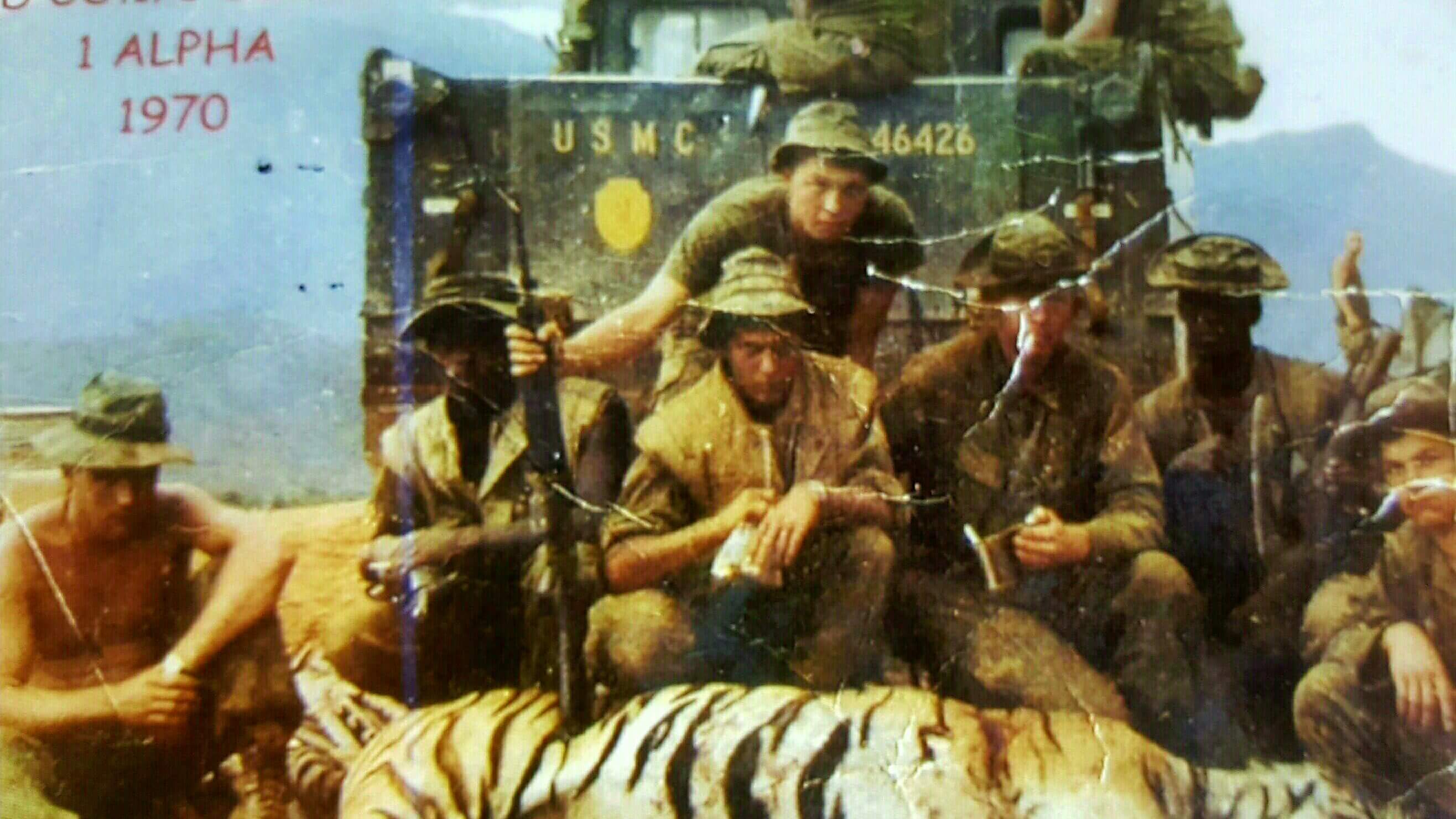 Soldiers looking tough, posing with the carcass of a tiger.