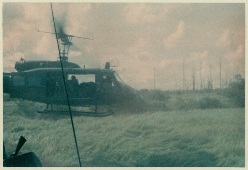 A helicopter taking off from a field.