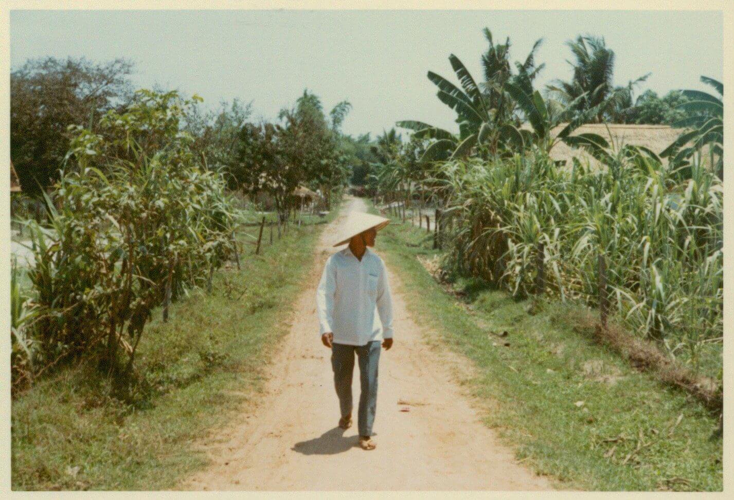 A Vietnamese civilian walking through fields.