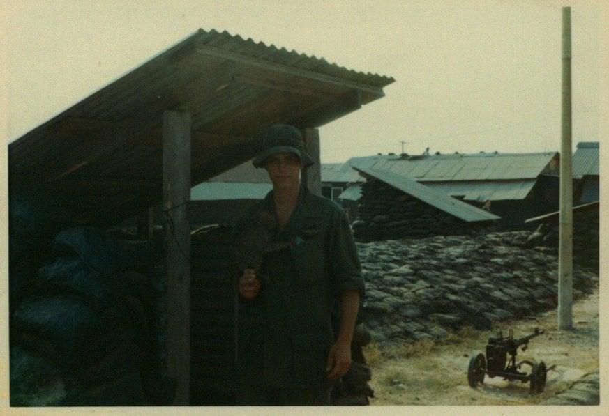 Young U.S. soldier standing outside an encampment.