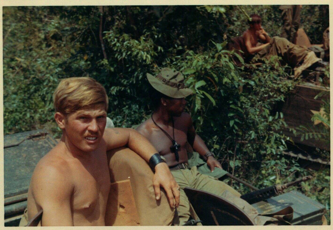 Young U.S. soldiers, shirtless in the jungle.