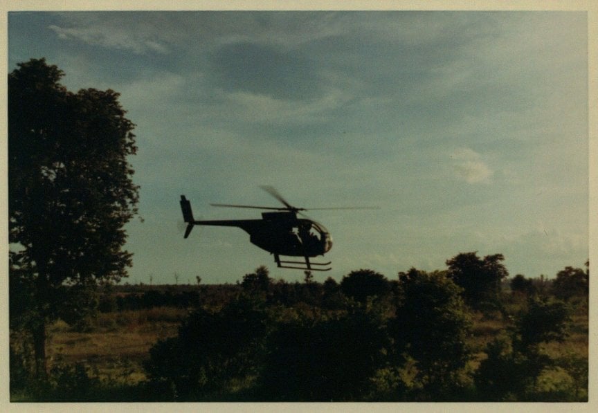 A helicopter landing in a clearing.