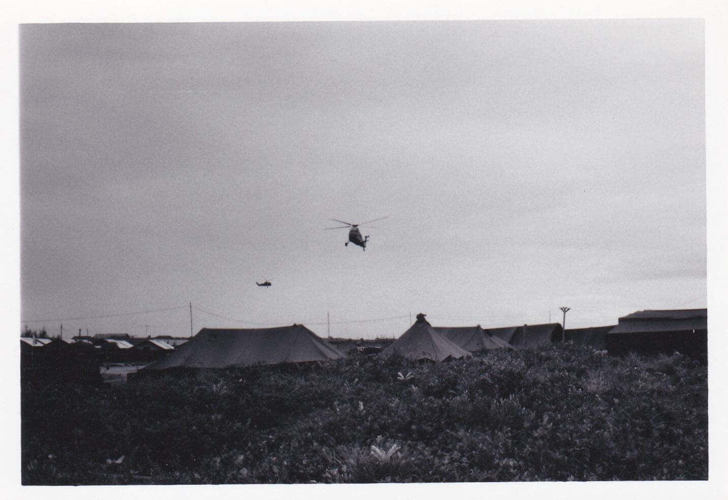 Choppers flying over a village.