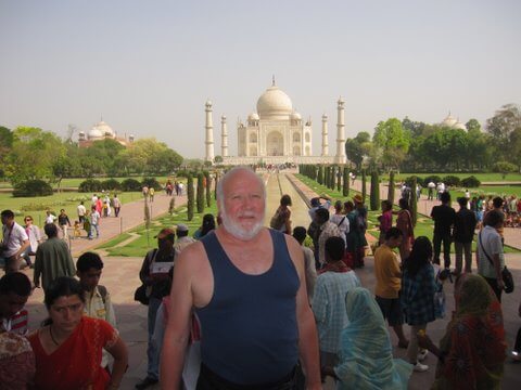 Older gentleman traveling, Taj Mahal in background.