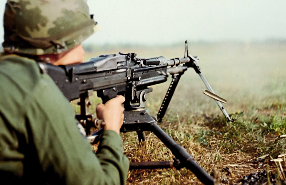 Soldier crouched behind a rifle.