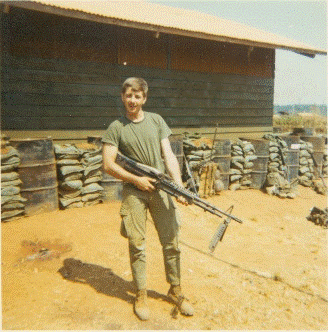 Young man outside holding a rifle.
