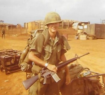 Young U.S. soldier outside in full gear, holding his rifle.