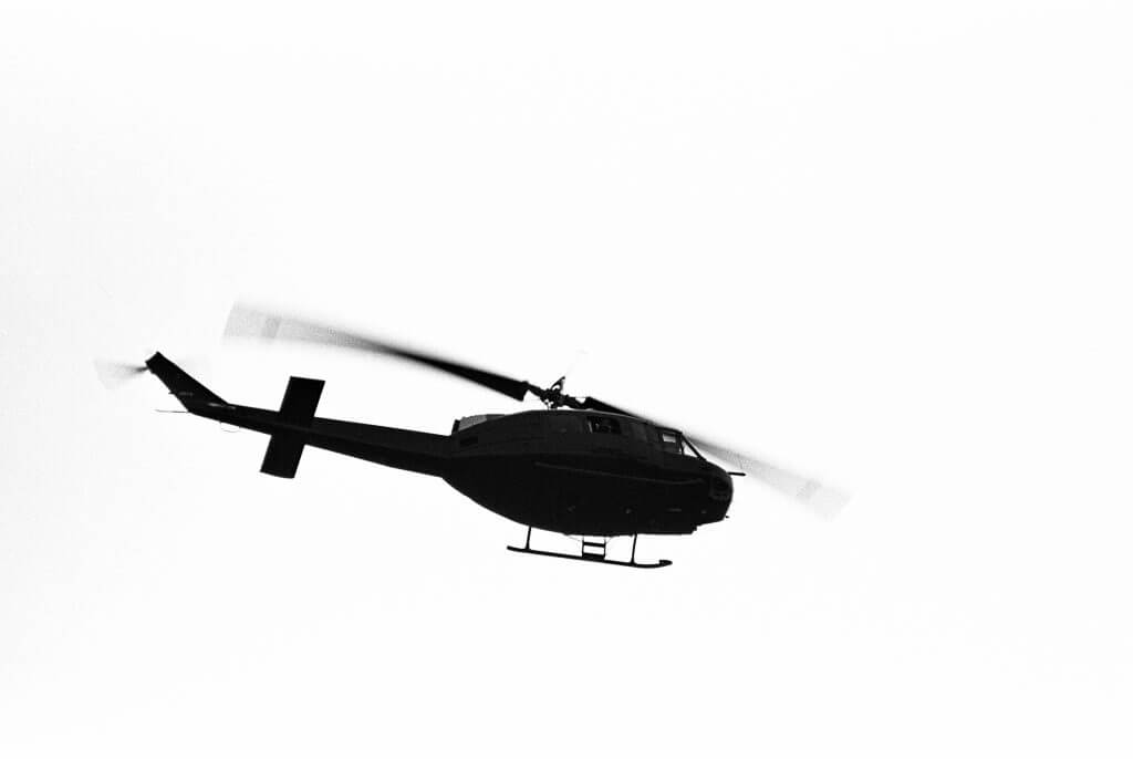 Silhouette of a chopper against a white sky.
