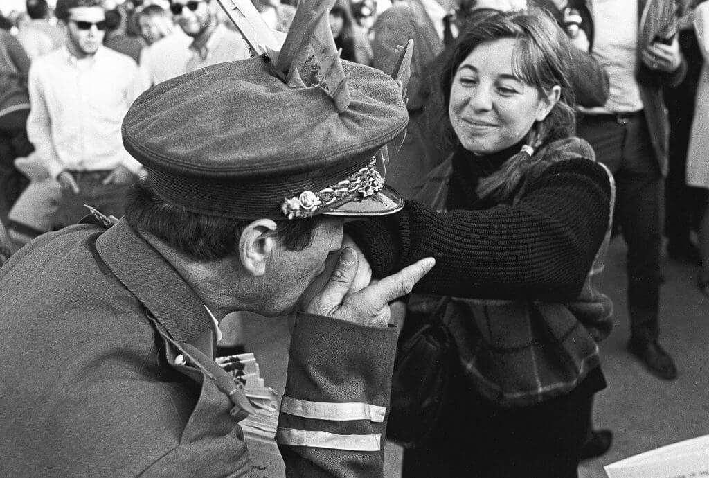 General Hersheybar kissing the hand of a young female protester.