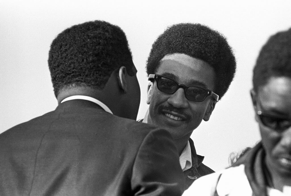 Muhammad Ali whispering to a black male protester's ear.