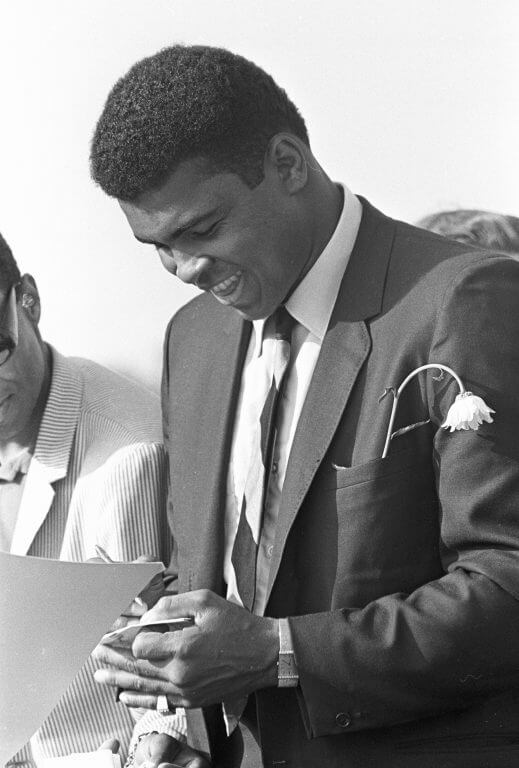 Muhammad Ali signing autographs.