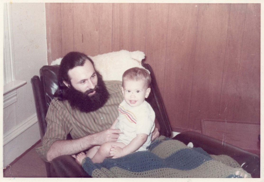 Infant sitting on father's lap.