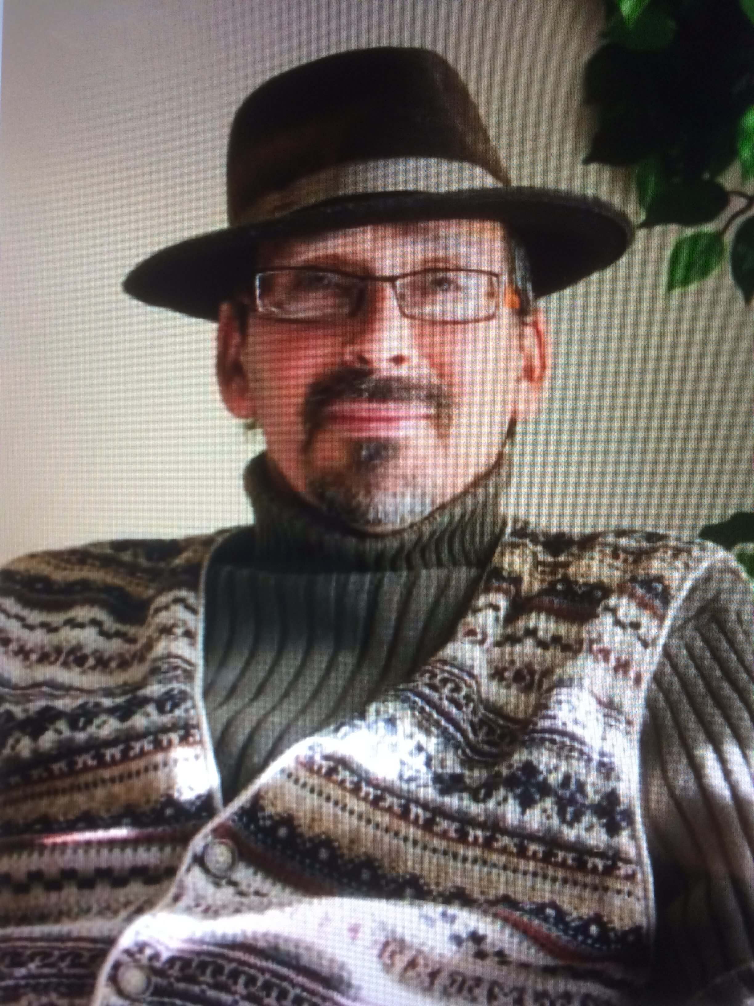 Photo of a man in a brown hat and sweater