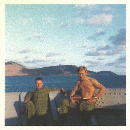 Two young soldiers relaxing on a boat.