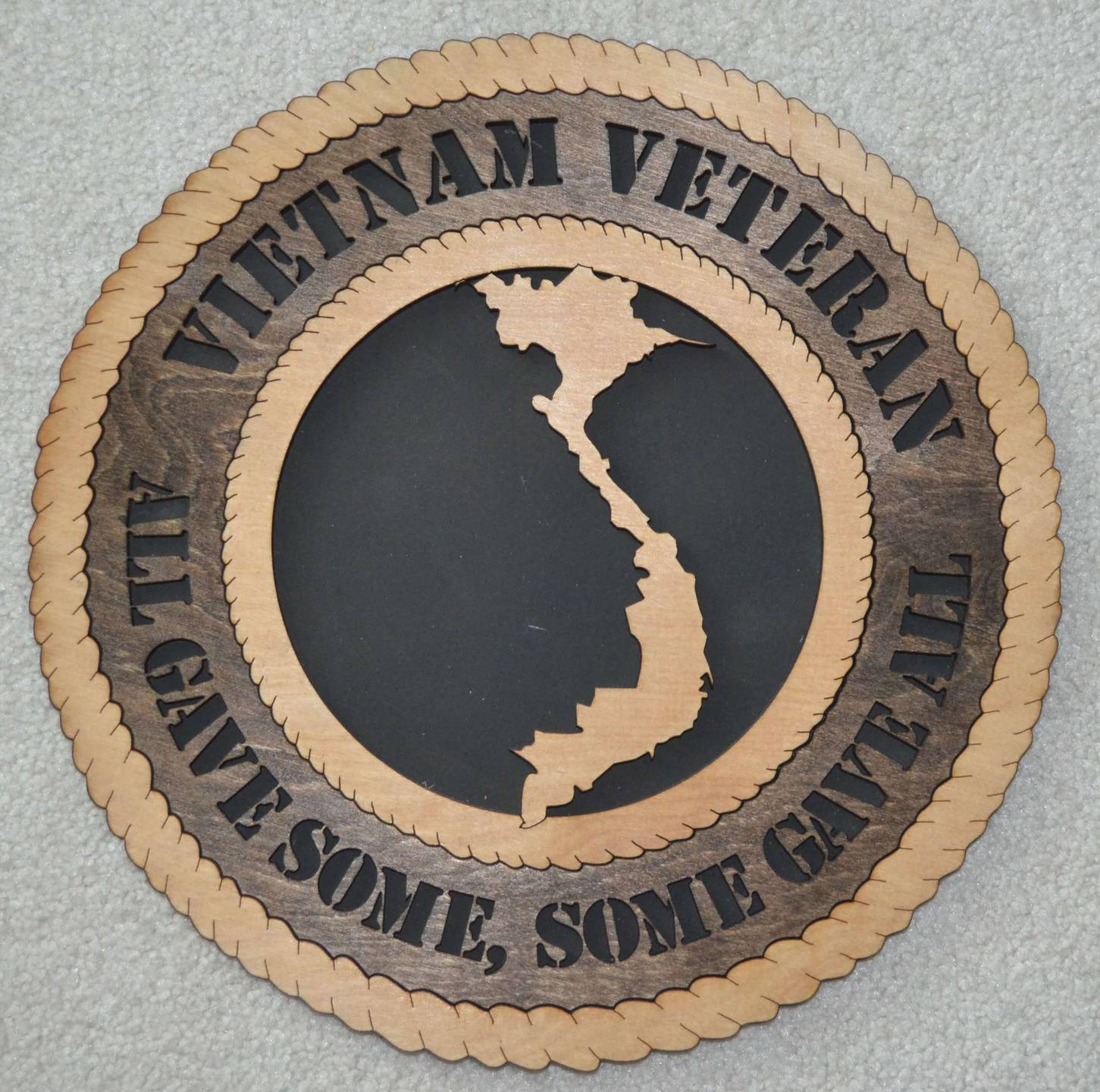 Laser-engraved token with an outline of Vietnam on it. Text reads: Vietnam Veteran; all gave some, some gave all.
