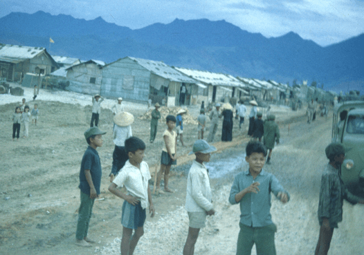 Young asian children on the streets of a village, mountains in the background.