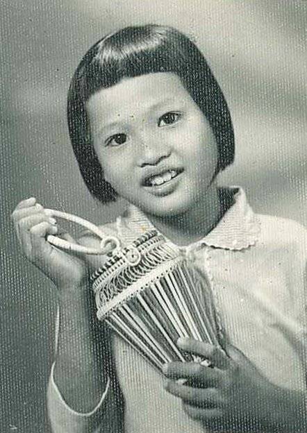 A portrait of a young Asian girl holding a small basket.