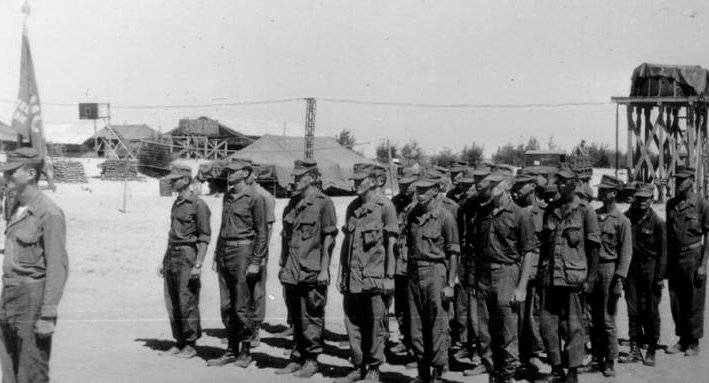 About a dozen U.S. soldiers in formation at a base camp.