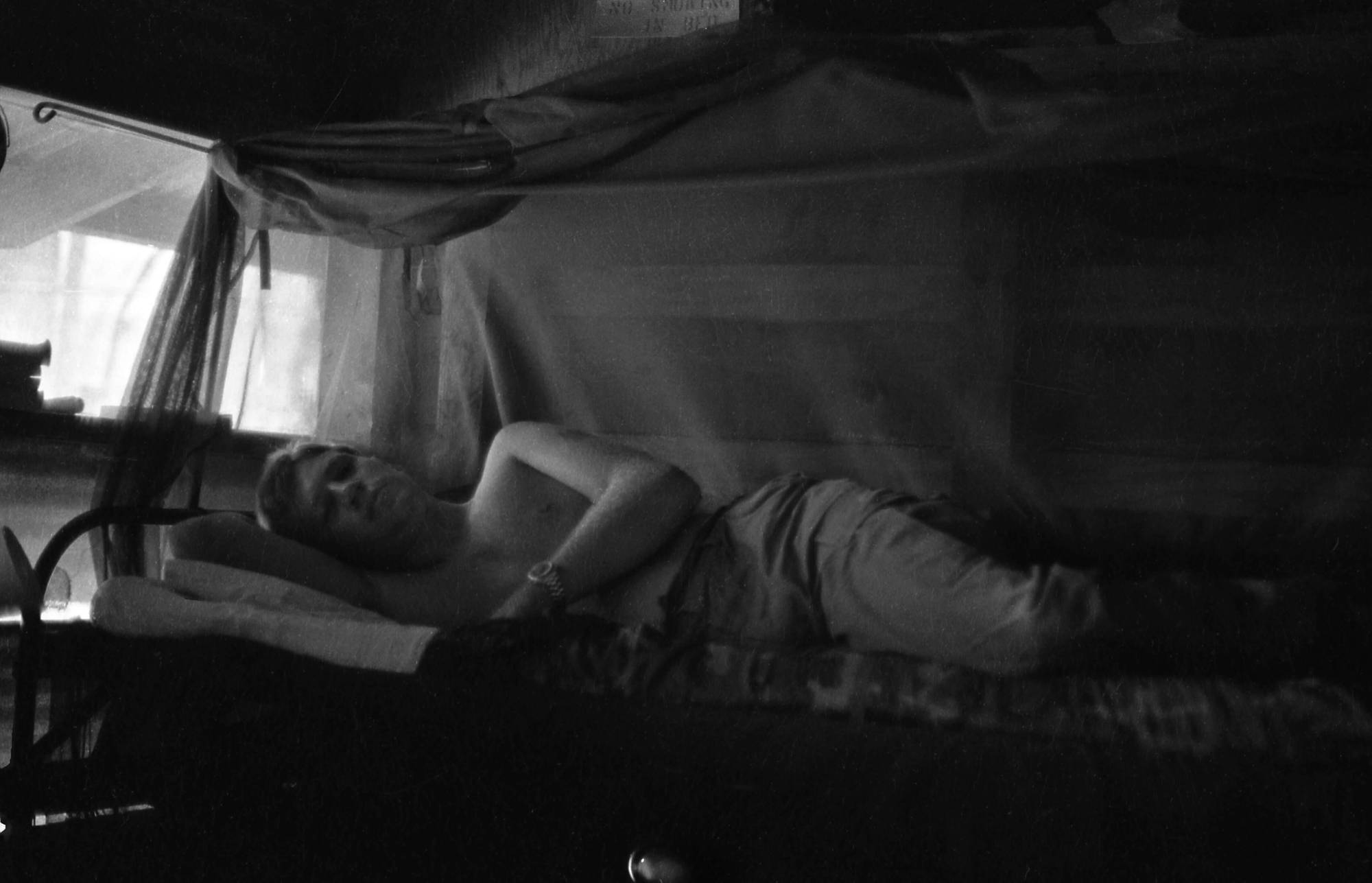 Soldier resting under mosquito netting.