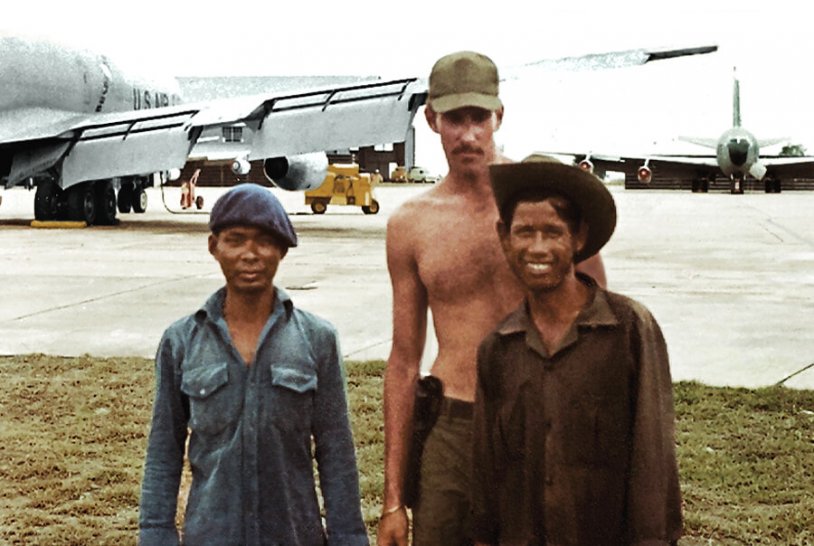 U.S. soldier with two young Asian men.