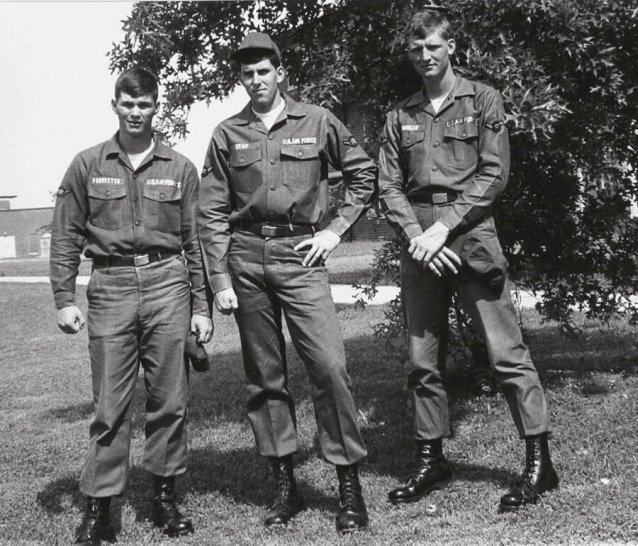 Three young U.S. soldiers posing by a tree.
