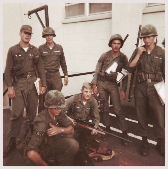 A group of U.S. soldiers standing outside a white building.