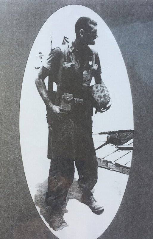 A grainy photo of a young man in full combat gear.