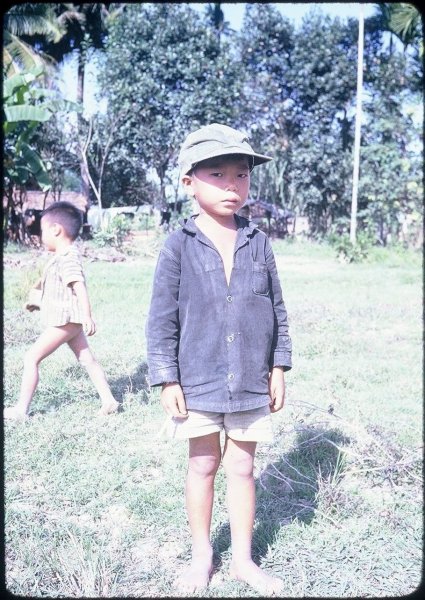Young Vietnamese boy in a ball cap and shirt.