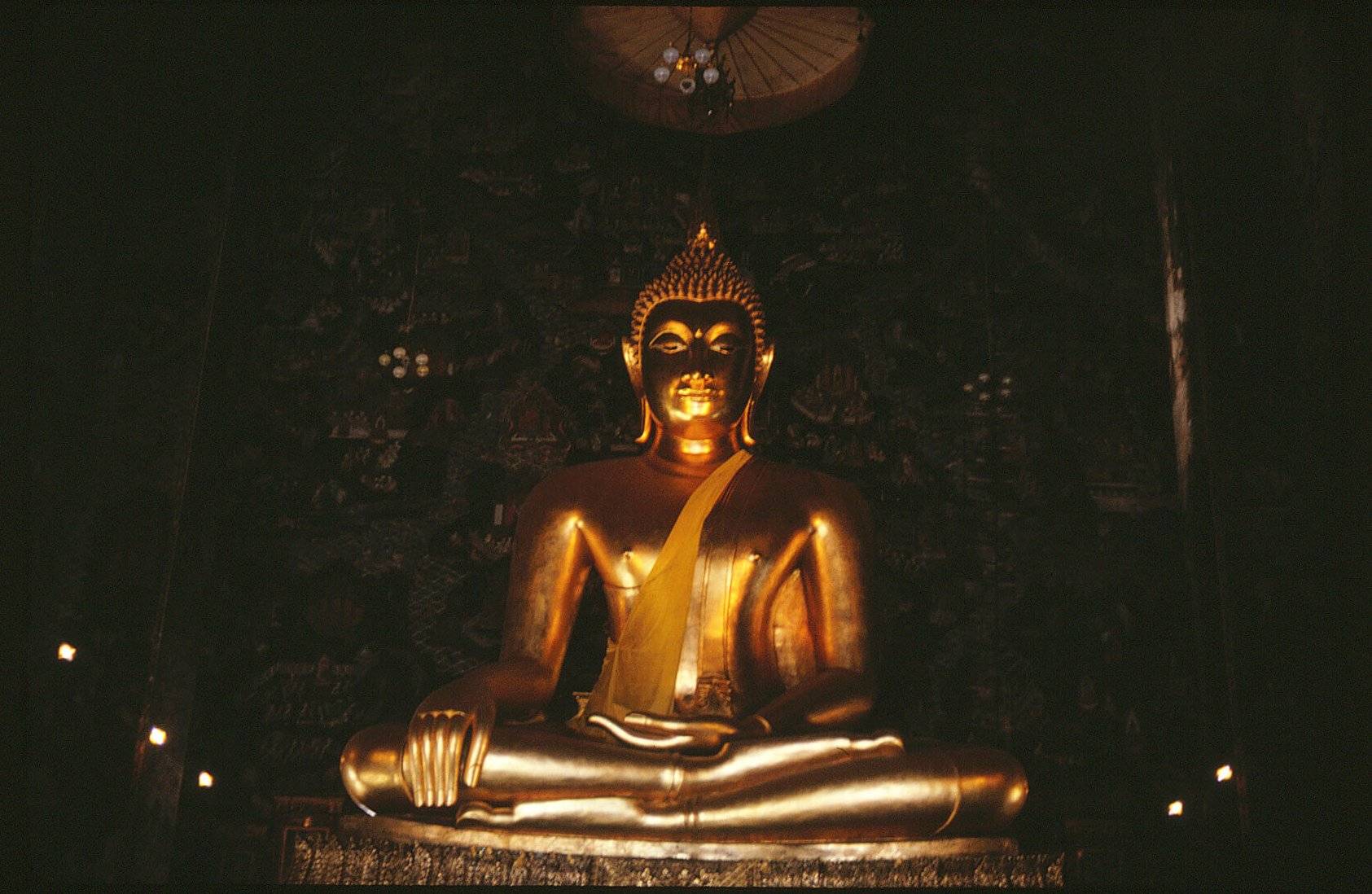 Interior statue in a Buddhist temple: a gilded figure seated cross-legged.