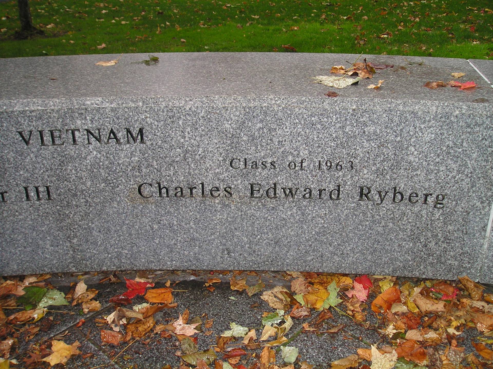 A granite memorial in the fall. Text reads: Class of 1963, Charles Edward Ryberg.