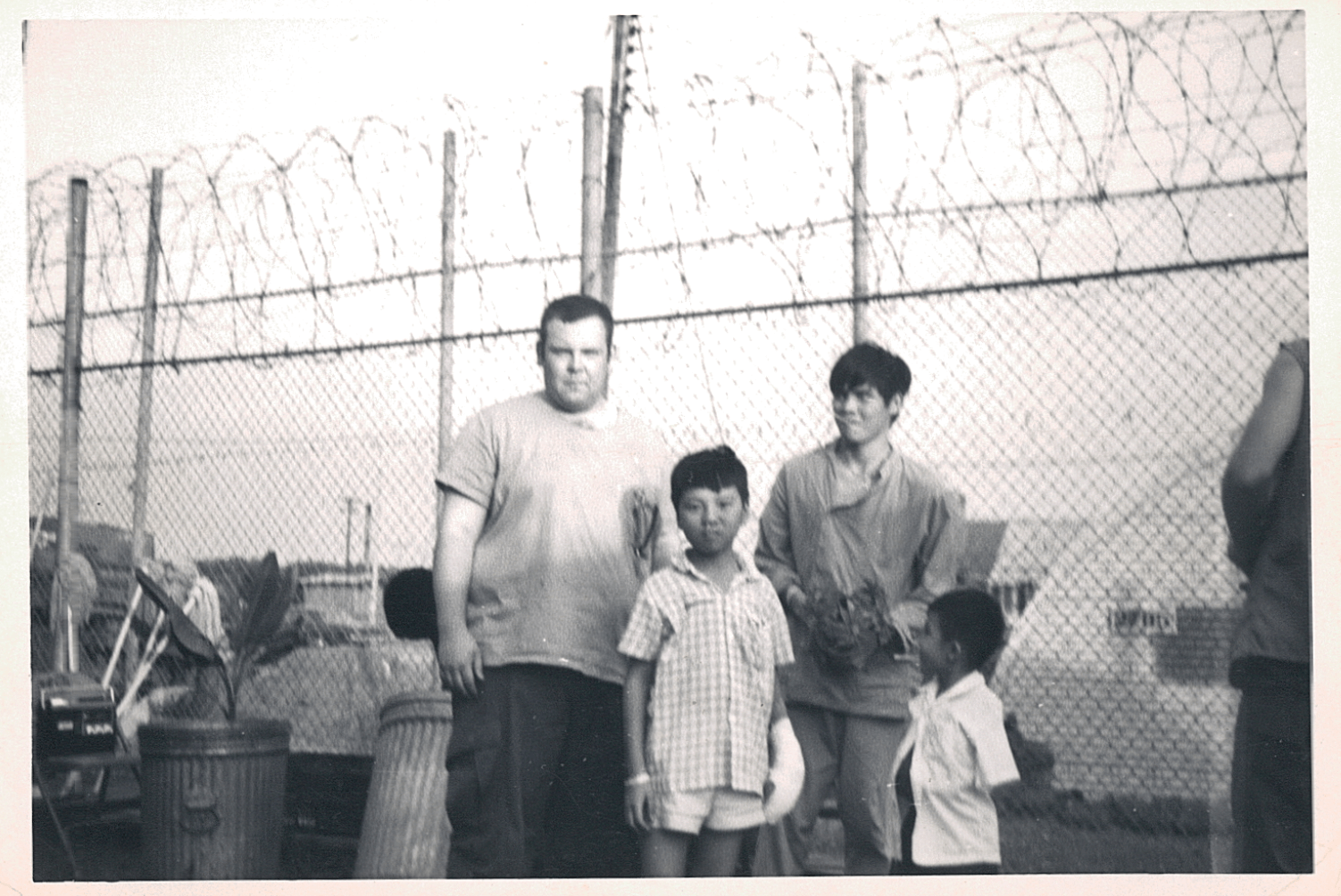 U.S. Soldier with an Asian young man and two small Asian children.