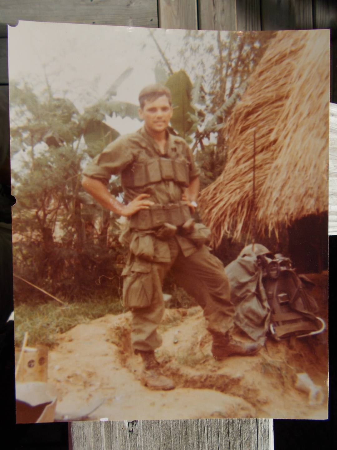 Young U.S. soldier in the jungle, hands on his hips.