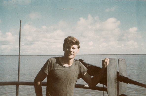 Young man standing on a boat on the water.