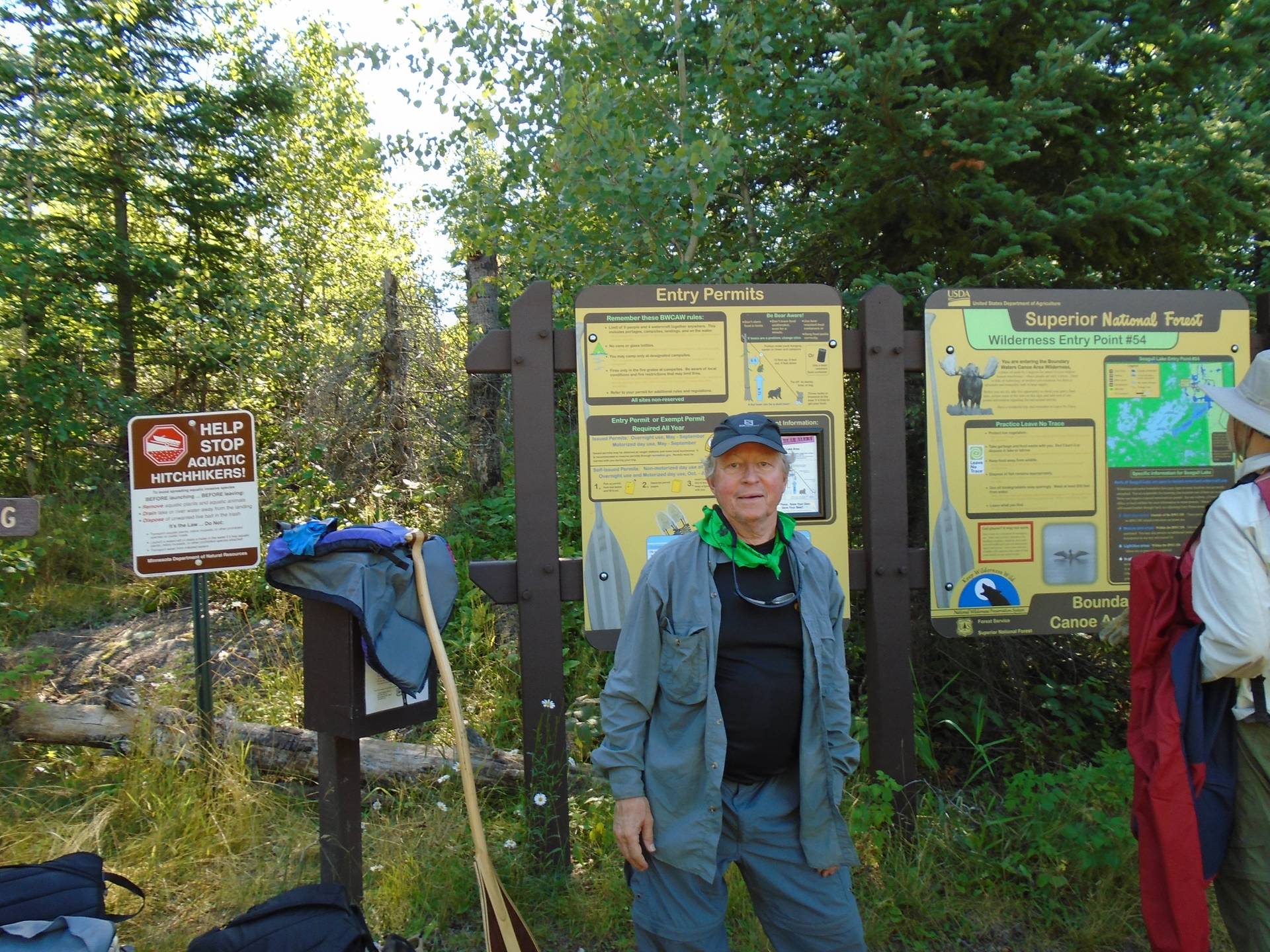 Contemporary photo of an older gentleman stopped at a trail head in the wilderness.