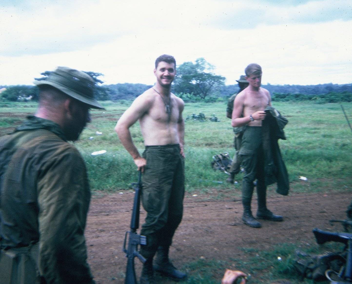 U.S. soldiers standing in a lush clearing.