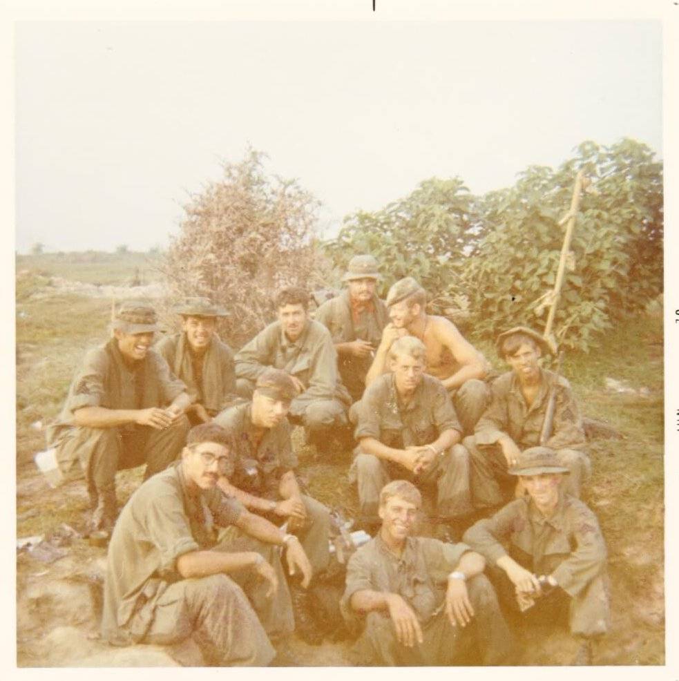 A group of U.S. soldiers hanging out in the wilderness.