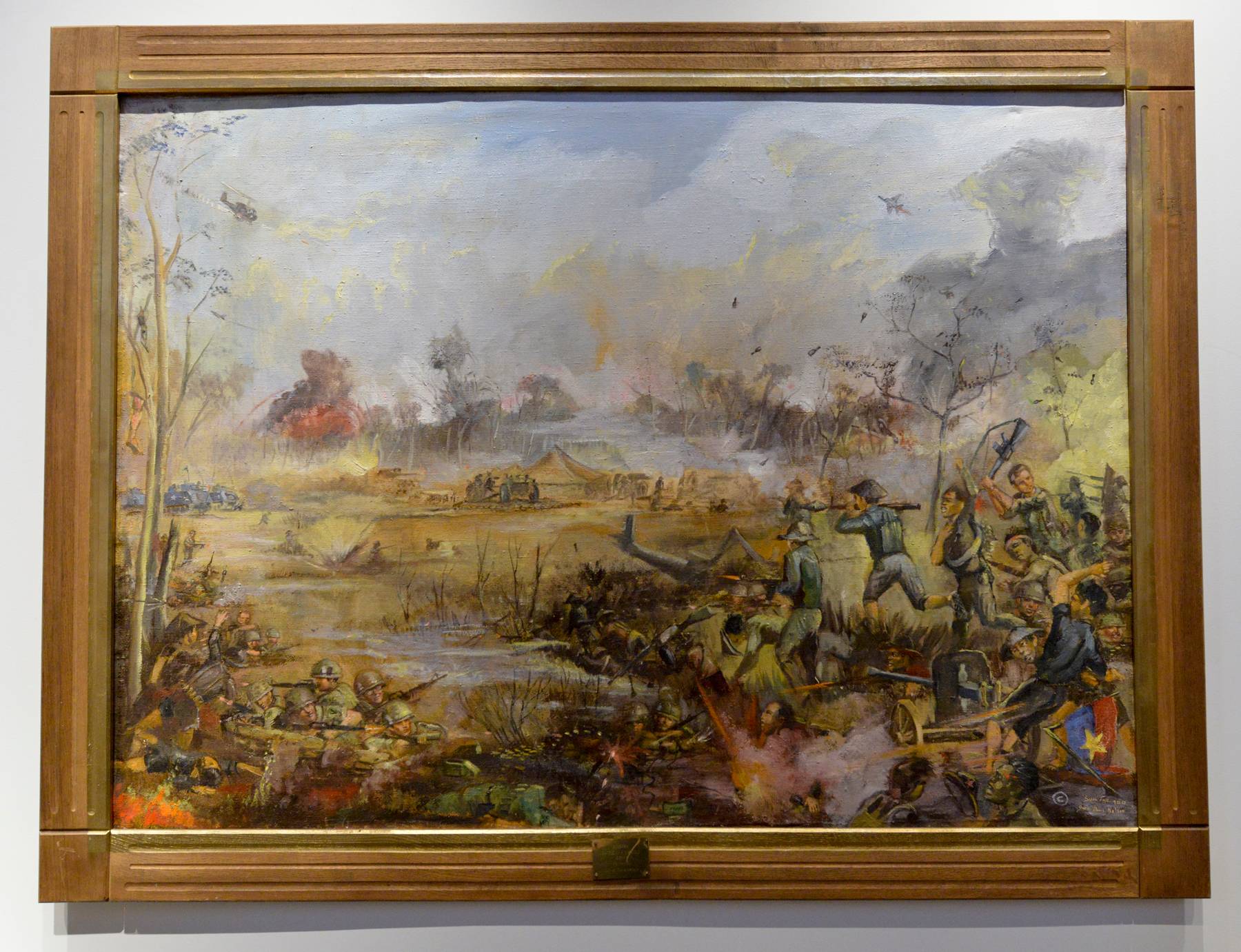 A framed painting depicting a battle between U.S. and National Liberation Front or Viet Cong forces.