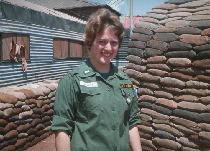 Vietnam War nurse in front of sandbags.