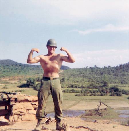 A young U.S. soldier shirtless, flexing for the camera.
