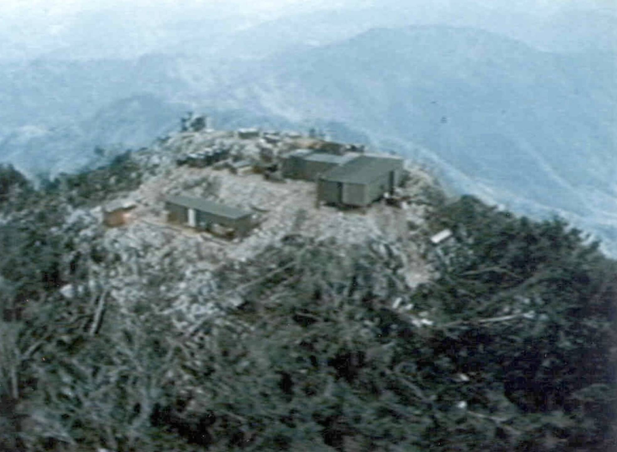 An aerial view of an encampment on the peak of a mountain.