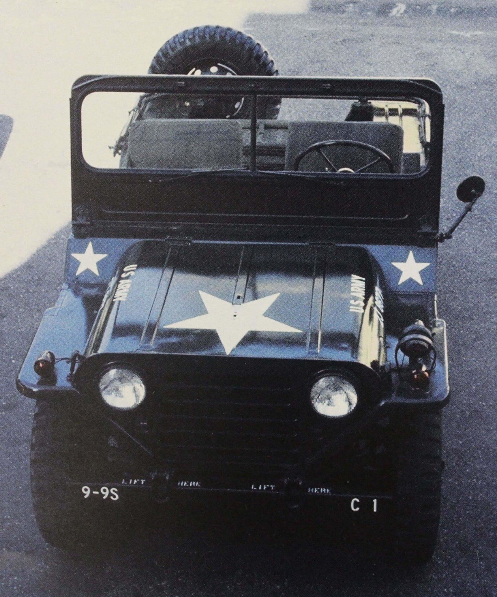 A black Army jeep with three white stars painted on it.