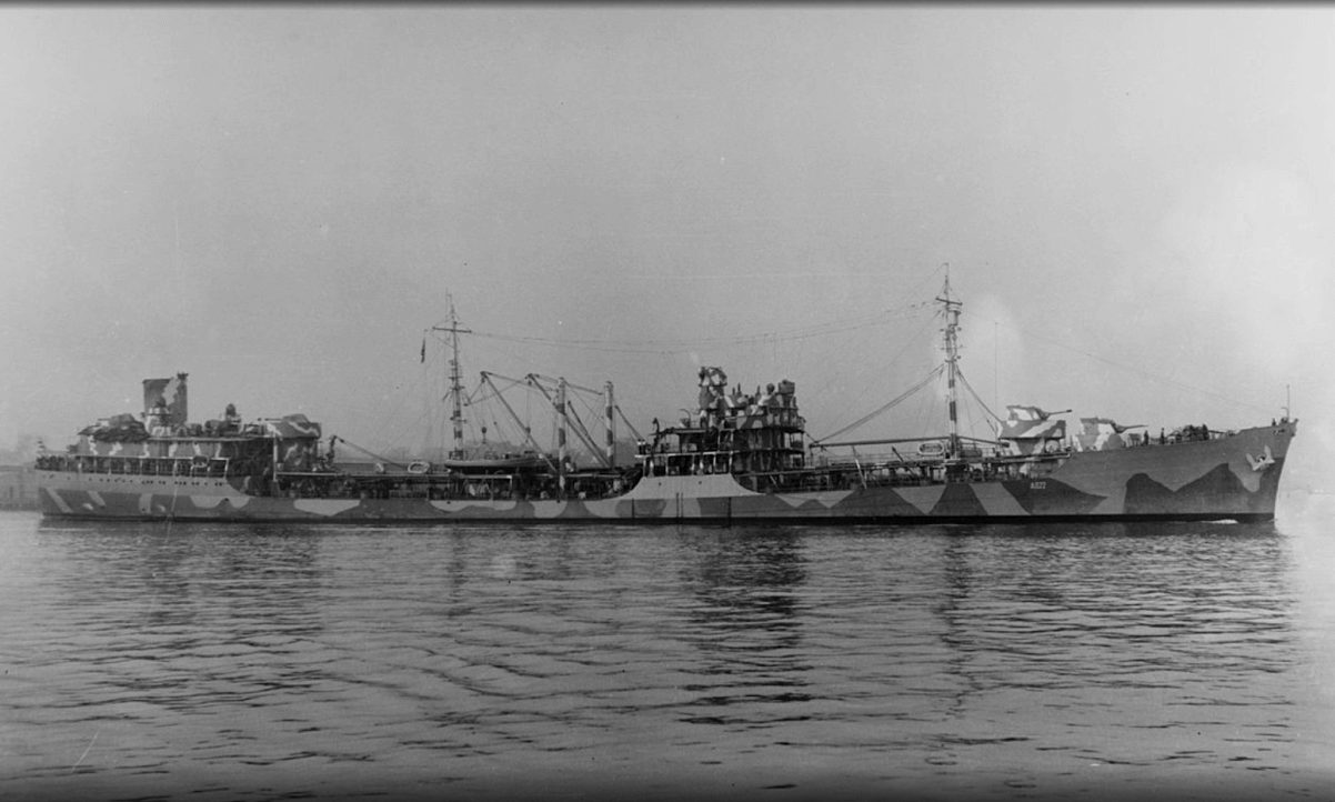 A large camo-painted ship on the water.