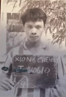 Young Hmong immigrant man holding a sign.