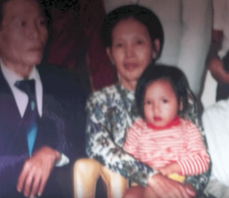Vietnamese grandparents holding child.