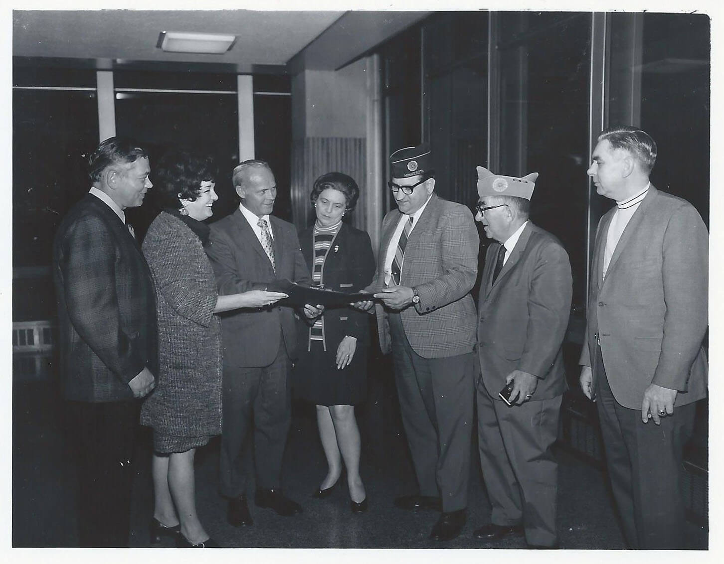 Civilian women, servicemen, and airport staff meeting and going over plans.