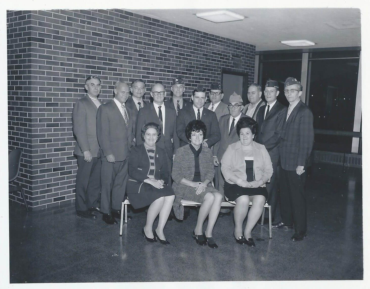 Civilian women, servicemen, and airport staff meeting and going over plans.