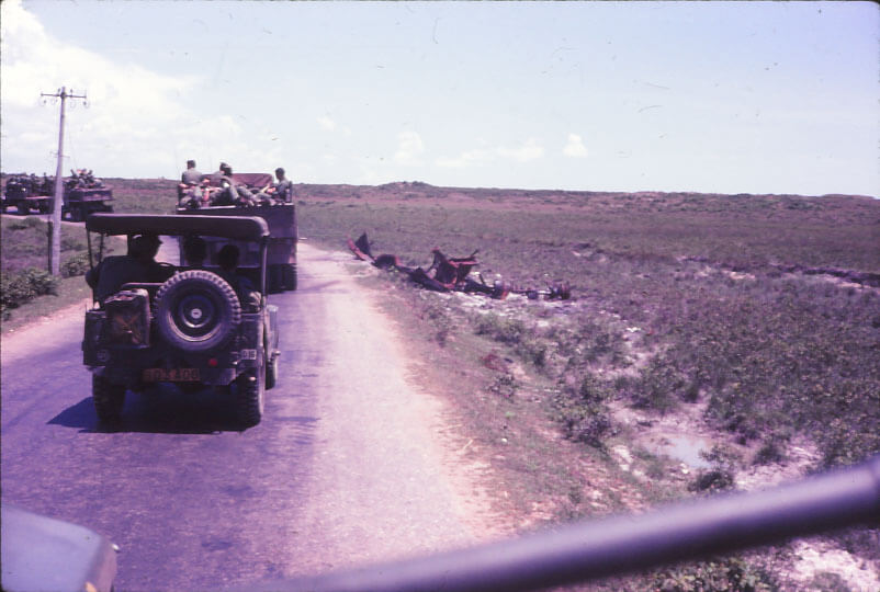 Photo taken from inside of a truck, looking at vehicles ahead in the convoy.
