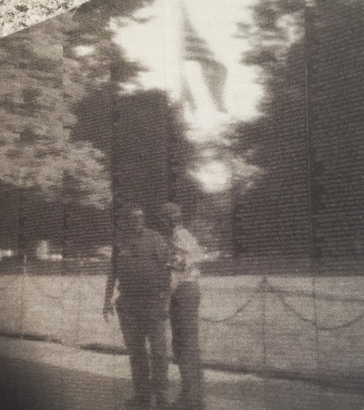 Two men reflected in the Vietnam War Memorial Wall in DC.